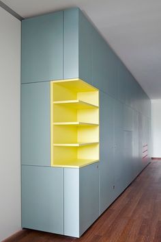 an empty room with some shelves on the wall and wood floors in front of it