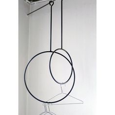 a black and white photo of a circular object hanging from a hook on a wall