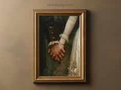 a painting of two hands holding each other in a gold frame on the wall above it