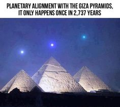 the three pyramids are lit up at night with two bright blue lights above them