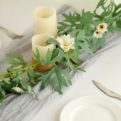 the table is set with candles, flowers and greenery for an elegant centerpiece