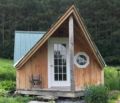 a small wooden cabin sitting on top of a lush green field