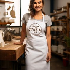 a woman in an apron is smiling for the camera