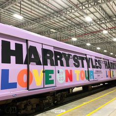 a train with the words harry styles painted on it's side is parked in a station