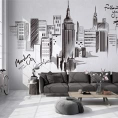 a living room filled with furniture next to a large wall mounted cityscape on the wall