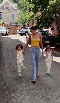 a woman and two children walking down the street