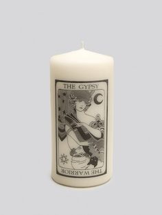 a white candle with an image of a woman holding a star and crescent on it