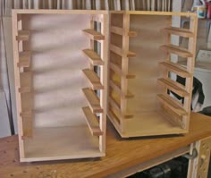 two empty wooden shelves sitting on top of a table next to a cat in the background