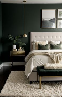 a bedroom with dark green walls and white bedding, rugs and pictures on the wall