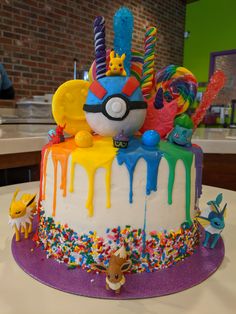 a birthday cake with sprinkles and decorations on it sitting on a table