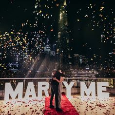 a man and woman standing on top of a red carpet covered in confetti