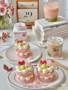 three small cakes are on a plate next to some books and a cup of coffee