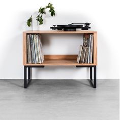 an old record player is on top of a wooden shelf with vinyl records in it