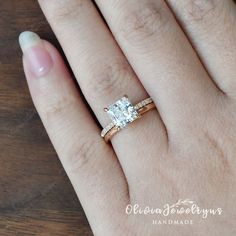 a woman's hand with a diamond ring on top of her finger and an engagement band