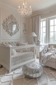 a baby's room with white furniture and chandelier