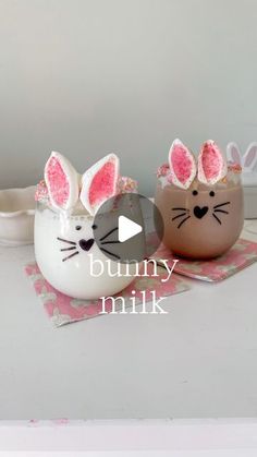 two decorated eggs sitting on top of a table next to each other with bunny ears