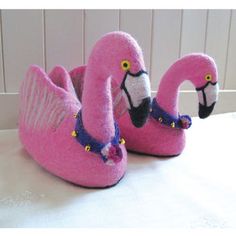 two pink flamingos sitting next to each other on a table