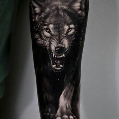 a man's leg with a wolf tattoo on it, and the image is black and white