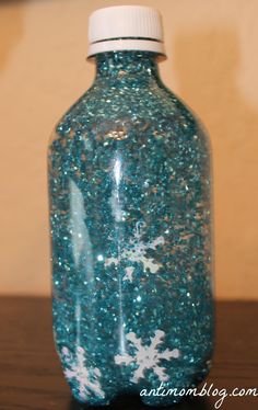 a bottle with snowflakes on it sitting on a table