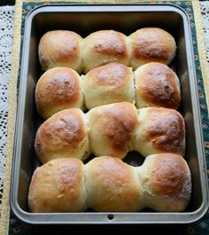 freshly baked rolls in a metal pan on a doily