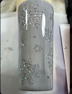 a vase with snowflakes on it sitting on a table next to other items