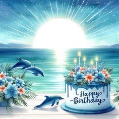 a birthday cake with dolphins and flowers in front of the ocean on a sunny day