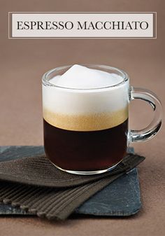 espresso machchato in a glass mug on a napkin with the words espresso machchato above it