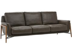 a brown leather couch with wooden legs and arm rests on an isolated white background,