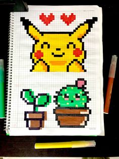 a notebook with some pixel art on top of it next to crayons and markers