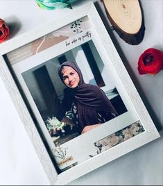 an image of a woman wearing a hijab in a frame next to flowers