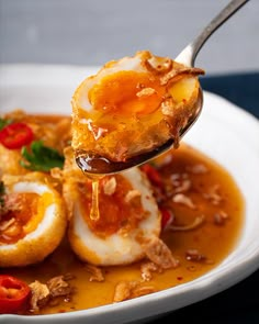 a spoonful of food is being lifted from a bowl filled with eggs and vegetables