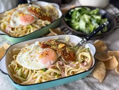 two bowls filled with pasta and topped with fried eggs