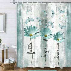 a shower curtain with blue flowers and dragonflies on the back of it, in front of a white wall