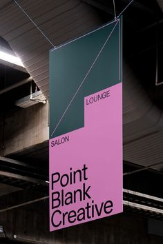 a pink and green sign hanging from the ceiling