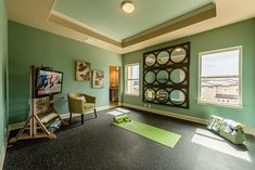 a yoga room with green walls and black carpet