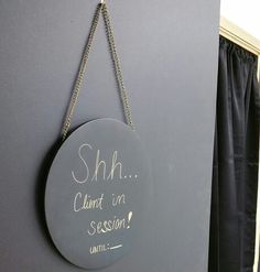 a sign that says shh i cannot't in session hanging on the wall