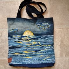 a blue bag with an image of two dolphins in the ocean on it's side