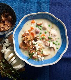 a blue and white bowl filled with food on top of a table