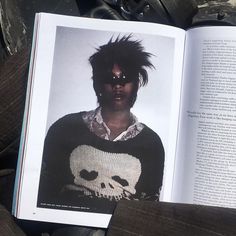 an open book with a photo of a person wearing a skull sweater