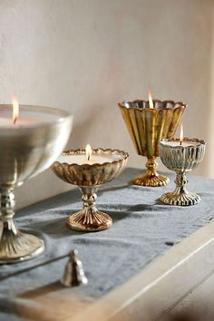 there are three candles on the table next to each other and one candle is lit