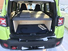 the back end of a green van with its cargo compartment open