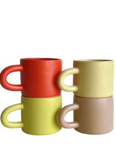 three different colored coffee mugs sitting next to each other