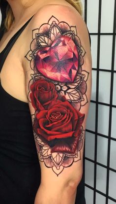 a woman's arm with two roses on it and a diamond in the middle