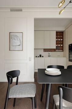 a black table and chairs in a small room with white walls on the other side