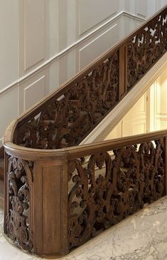 an ornate wooden banister with marble flooring