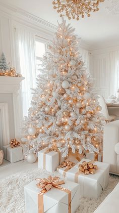 a white christmas tree with presents under it