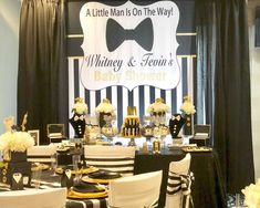 a black and white themed baby shower is set up on the stage with gold accents