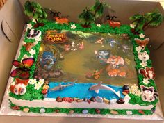 a birthday cake in the shape of a box with animals and plants on it's sides