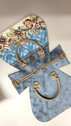 two pieces of blue and gold purses on top of each other, one with a flowered design