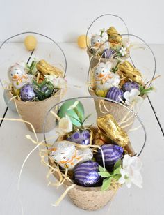 three baskets filled with chocolate eggs and flowers